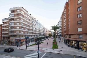 eine Straße in einer Stadt mit hohen Gebäuden und Menschen in der Unterkunft La Ventana De Paco in Oviedo