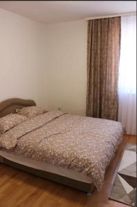 a bedroom with a bed and a window with curtains at Apartment Ilidza-SK 2 in Sarajevo