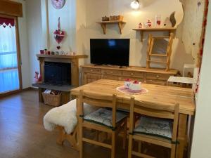 a dining room with a table and a television at Edelweiss Apt29 in Pretoro +5 photos