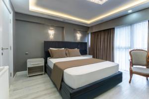 - une chambre avec un grand lit et une chaise dans l'établissement Classio Hotel Kadıköy, à Istanbul