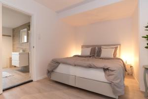 a white bedroom with a bed and a mirror at Studio Loet in Schagen