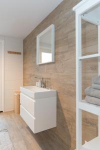 a bathroom with a white sink and a mirror at Studio Loet in Schagen