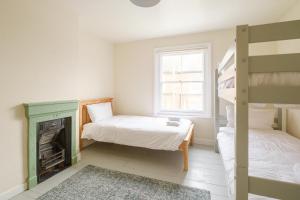 a bedroom with two bunk beds and a fireplace at 41 Eastward Ho in Leiston