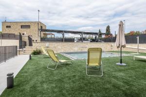 two chairs and an umbrella sitting on a lawn at Passioncasa in Torri del Benaco