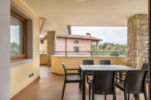 a dining room with a table and chairs on a balcony at Passioncasa in Torri del Benaco