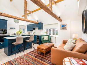 eine Küche und ein Wohnzimmer mit blauen Schränken und einem Sofa in der Unterkunft Pass the Keys Converted Hop House Apt - Old Amersham - Chilterns in Amersham