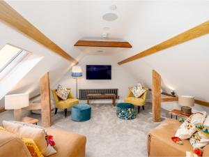 a attic living room with furniture and a tv at Pass the Keys Converted Hop House Apt - Old Amersham - Chilterns in Amersham