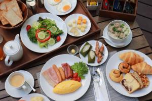 uma mesa com pratos de comida para o pequeno almoço em Grande Centre Point Ploenchit em Banguecoque