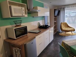 une cuisine avec un four micro-ondes sur un comptoir et une table dans l'établissement Gîte Évasion idyllique, à Faverolles-sur-Cher