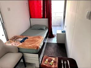 アブダビにあるPhenomenal Room "Sea View"の小さなベッドルーム(ベッド1台、椅子付)