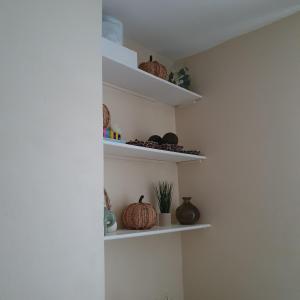 a room with white shelves with vases on them at sweet dreams A in London