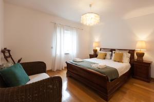a bedroom with a bed and a couch at FLH Restelo Duplex with Garden & Parking in Lisbon