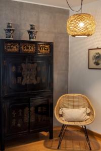 a room with a cabinet and a chair and a lamp at FLH Restelo Duplex with Garden & Parking in Lisbon