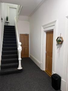 a hallway with a staircase and a door and a stair case at Serendipity By Habitat101 in Middlesbrough