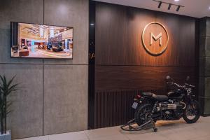 a motorcycle parked in front of a wall with a sign at My Lan Hanoi Hotel in Hanoi