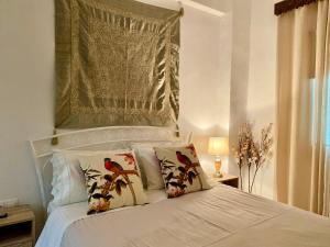 a bedroom with a white bed with pillows on it at Katoi House - Central Skyros Village in Skiros