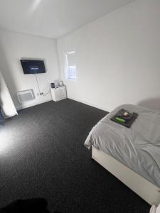 a bedroom with a bed and a flat screen tv at Serendipity By Habitat101 in Middlesbrough
