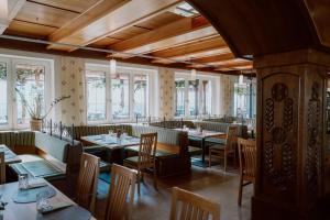 a restaurant with tables and chairs and windows at Mahorko Wein Wellness Wasserbüffel in Glanz an der Weinstraße