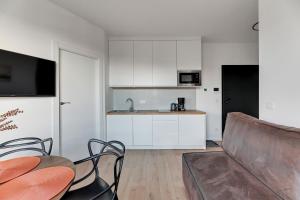 a living room with a couch and a kitchen at DOKI Living & Foodhall Apartament in Gdańsk