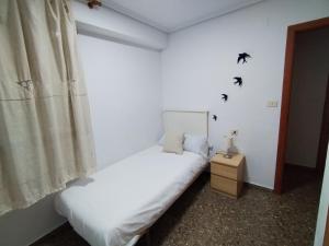 a bedroom with two beds and a window with birds on the wall at COSTA AZUL in Puerto de Sagunto