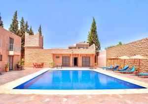 una piscina frente a un edificio de ladrillo en bungalows vert 2, en Essaouira