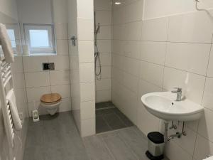 a white bathroom with a sink and a toilet at Timeless: Große Moderne 4 Zimmer Wohnung in Ludwigsburg