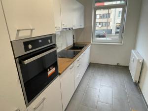 eine Küche mit weißen Schränken und einem schwarzen Backofen in der Unterkunft Timeless: Große Moderne 4 Zimmer Wohnung in Ludwigsburg