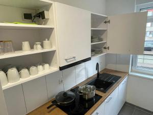 a kitchen with white cabinets and a stove top oven at Timeless: Große Moderne 4 Zimmer Wohnung in Ludwigsburg