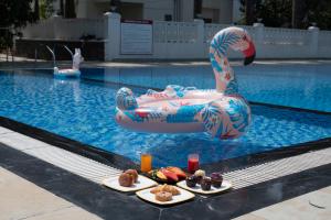 a pool with three plates of food in a swimming pool at Sterling Stolen Heaven Lonavala in Lonavala