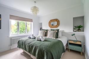 a bedroom with a bed with a green blanket and a mirror at The Birdie in York