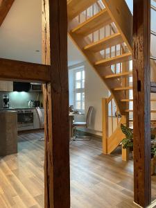 a kitchen and a living room with wooden stairs at Ferienwohnungen Zum Neuhäusel in Quedlinburg