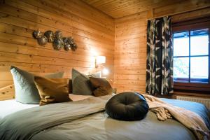 ein Schlafzimmer mit einem großen Bett an einer Holzwand in der Unterkunft Bergfreude Chalet in Braunlage