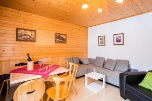uma sala de estar com um sofá e uma mesa com uma mesa em Apartment Paletti 23 em Enzingerboden