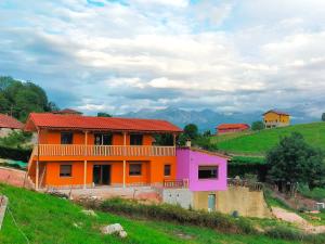 an orange and pink house on top of a hill at PicuAstur in Cangas de Onís