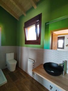 a bathroom with a black sink and a toilet at PicuAstur in Cangas de Onís