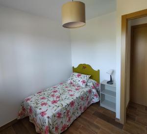 a bedroom with a bed with a floral bedspread at PicuAstur in Cangas de Onís