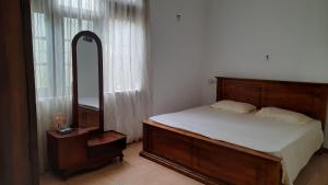 een slaapkamer met een groot bed en een spiegel bij Party Allowed luxury 4 roomed Furnished house in Jaela in Ja-Ela