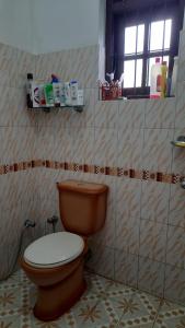 een badkamer met een bruin toilet en een raam bij Party Allowed luxury 4 roomed Furnished house in Jaela in Ja-Ela