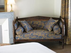 a couch with pillows on it in a bedroom at Chambres d'hôtes -B&B- La Bonneterie in Montaigut-le-Blanc