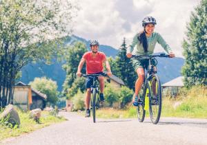 dos personas montando bicicletas por un camino en Britof Forest House in Chestnut Valley en Kanal