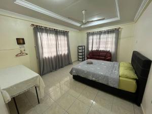 a bedroom with a bed and a table in it at [El Casa] Homestay Miri (8 Pax) in Miri