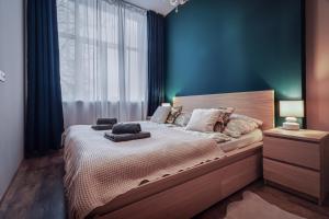 波普拉德的住宿－Apartmán Poprad Veľká，一间卧室设有一张带蓝色墙壁和窗户的大床