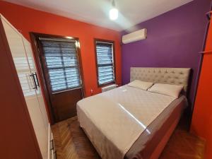 a bedroom with a bed with purple and orange walls at Sarı Köşk Butik Otel in Bursa