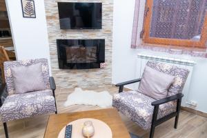 a living room with two chairs and a fireplace at Praška zima in Jahorina