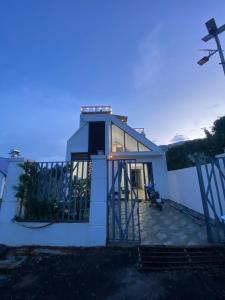 een klein wit huis met een balkon bij zonsondergang bij Căn hộ S'pung Villa in Bao Loc +8 foto's