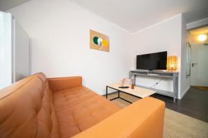 a living room with a couch and a tv at Favorite Stays -Suite and More - Altstadt in Düsseldorf