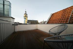 a balcony with a chair and a clock tower at Favorite Stays -Suite and More - Altstadt in Düsseldorf