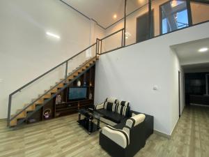 een woonkamer met een bank en een trap bij Căn hộ S'pung Villa in Bao Loc