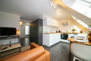 a living room with a couch and a kitchen at Favorite Stays -Suite and More - Altstadt in Düsseldorf
