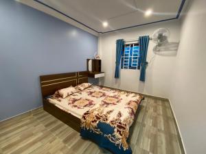 een slaapkamer met een bed en een ventilator bij Căn hộ S'pung Villa in Bao Loc